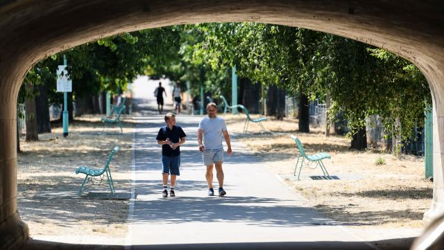 (260814) -- PARIS, Aug. 14, 2026 (Xinhua) -- People walk in a park near the Seine River during a heatwave in Paris, France, Aug. 14, 2026. (Xinhua/Wu Huiwo)