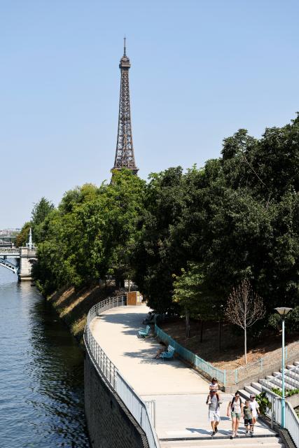 (260814) -- PARIS, Aug. 14, 2026 (Xinhua) -- People walk in a park near the Seine River during a heatwave in Paris, France, Aug. 14, 2026. (Xinhua/Wu Huiwo)