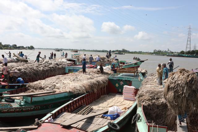 (260814) -- MUNSHIGANJ, Aug. 14, 2026 (Xinhua) -- People trade jute at a floating jute market in Munshiganj, Bangladesh, Aug. 14, 2026. (Photo by Habibur Rahman/Xinhua)
