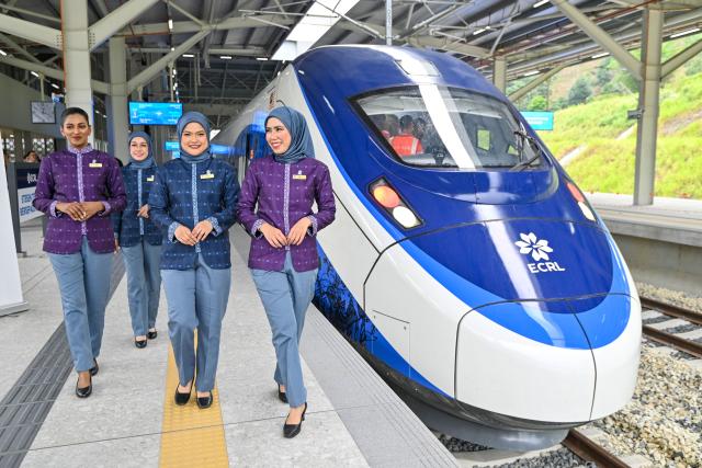(260814) -- SELANGOR, Aug. 14, 2026 (Xinhua) -- Train attendants walk past a train at the Gombak station of the East Coast Rail Link (ECRL) in Selangor state, Malaysia, Aug. 14, 2026. The East Coast Rail Link (ECRL), a mega rail project in Malaysia being built by the China Communications Construction Company (CCCC), is expected to begin commercial operations by January 2027, Transport Minister Anthony Loke Siew Fook said on Friday.
  In the meantime, the railway has reached 95.08 percent overall progress and has entered its testing and commissioning phase, keeping with its project schedule, Loke said in his speech at the launch ceremony of the ECRL Comprehensive Inspection Train (CIT). (Photo by Chong Voon Chung/Xinhua)