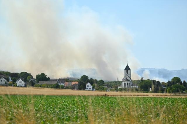 (260814) -- GEY, Aug. 14, 2026 (Xinhua) -- Smoke rises from a forest in Gey, Germany, Aug. 14, 2026. According to German media reports, a wildfire broke out in North Rhine-Westphalia, and over 2,000 residents were evacuated as a precaution for safety reasons. (Photo by Ulrich Hufnagel/Xinhua)