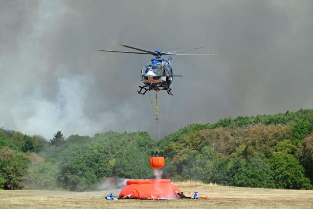 (260814) -- GEY, Aug. 14, 2026 (Xinhua) -- A helicopter fetches water to extinguish a wildfire in Gey, Germany, Aug. 14, 2026. According to German media reports, a wildfire broke out in North Rhine-Westphalia, and over 2,000 residents were evacuated as a precaution for safety reasons. (Photo by Ulrich Hufnagel/Xinhua)
