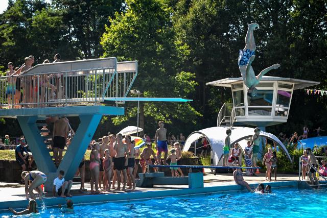 (260814) -- DELDEN, Aug. 14, 2026 (Xinhua) -- A man jumps into an outdoor swimming pool in Delden, the Netherlands, Aug. 14, 2026. The Royal Netherlands Meteorological Institute (KNMI) issued a yellow heat warning on Aug. 14, 2026, as temperatures reached 35 degrees Celsius, marking the fifth heatwave in the Netherlands this year. (Photo by Eric Brinkhorst/Xinhua)