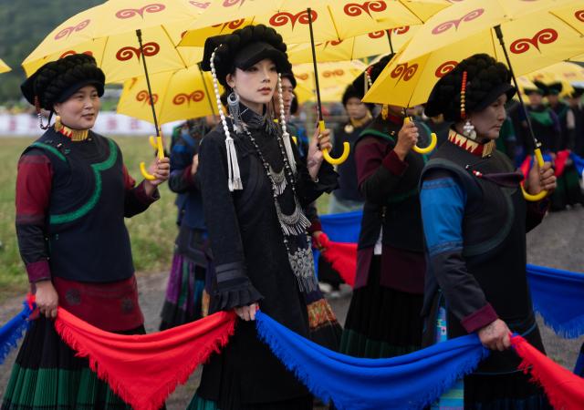 (260815) -- CHENGDU, Aug. 15, 2026 (Xinhua) -- Locals of the Yi ethnic group display traditional outfits in Xinhua Village of Yuexi County, southwest China's Sichuan Province, Aug. 3, 2026.
  TO GO WITH "China Focus: Torch Festival flames light up more benefits in SW China" (Xinhua/Jiang Hongjing)