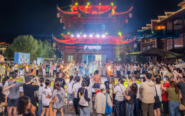 (260815) -- ZHANGJIAJIE, Aug. 15, 2026 (Xinhua) -- Tourists watch a performance at Dayong Ancient Town in Zhangjiajie, central China's Hunan Province, Aug. 14, 2026.
  Leveraging its rich intangible cultural heritage, the city of Zhangjiajie has developed diverse summer getaways and multiple forms of night tours, fueling a travel boom during the peak season. (Photo by Li Jian/Xinhua)