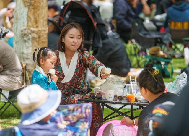 (260815) -- LHASA, Aug. 15, 2026 (Xinhua) -- People enjoy leisure time at Norbulingka in Lhasa, southwest China's Xizang Autonomous Region, on Aug. 15, 2026. "Lingka" means "garden" in the Tibetan language. In Xizang, people follow a tradition of spending the Lingka time, when they camp out and have picnics in parks or suburbs. During the traditional Shoton Festival holiday, which runs from Aug. 14 to 16 this year, people enjoy Lingka time with family and friends. (Xinhua/Tenzin Nyida)