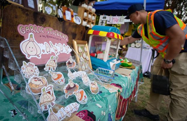 (260815) -- RICHMOND, Aug. 15, 2026 (Xinhua) -- Garlic-themed stickers are displayed at a booth during the Richmond Garlic Fest in Richmond, British Columbia, Canada, Aug. 15, 2026. (Photo by Liang Sen/ Xinhua)