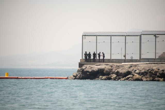 (260815) -- CEUTA, Aug. 15, 2026 (Xinhua) -- Security personnel work at the border of Ceuta, Spain, Aug. 15, 2026. More than 72,000 migrants crossed irregularly into Ceuta from neighboring Morocco on July 30 and 31, according to the Spanish government. Most returned to Morocco later, while thousands remain in the enclave.Security was also tightened along the border ahead of Saturday after calls for another mass crossing circulated on social media. Moroccan security forces intercepted hundreds of migrants attempting to reach the border area, while Ceuta reported no influx on a scale comparable to that seen in late July. (Xinhua/Cheng Min)