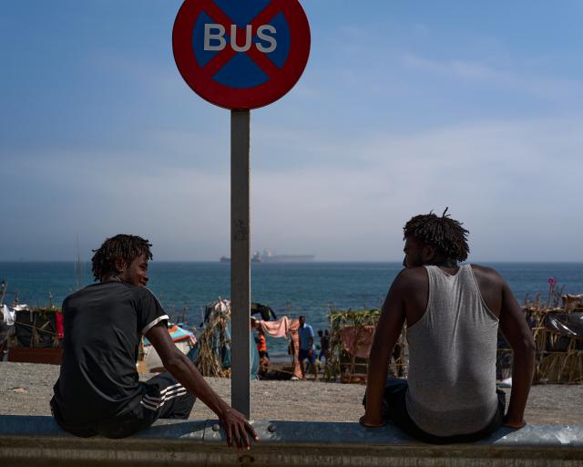 (260815) -- CEUTA, Aug. 15, 2026 (Xinhua) -- Irregular migrants sit at the Trampolin Beach in Ceuta, Spain, Aug. 15, 2026. More than 72,000 migrants crossed irregularly into Ceuta from neighboring Morocco on July 30 and 31, according to the Spanish government. Most returned to Morocco later, while thousands remain in the enclave.Security was also tightened along the border ahead of Saturday after calls for another mass crossing circulated on social media. Moroccan security forces intercepted hundreds of migrants attempting to reach the border area, while Ceuta reported no influx on a scale comparable to that seen in late July. (Xinhua/Meng Dingbo)