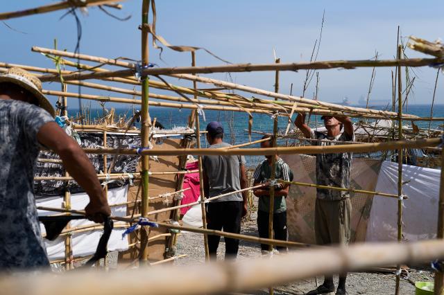 (260815) -- CEUTA, Aug. 15, 2026 (Xinhua) -- Irregular migrants build makeshift shelters in Ceuta, Spain, Aug. 15, 2026. More than 72,000 migrants crossed irregularly into Ceuta from neighboring Morocco on July 30 and 31, according to the Spanish government. Most returned to Morocco later, while thousands remain in the enclave.Security was also tightened along the border ahead of Saturday after calls for another mass crossing circulated on social media. Moroccan security forces intercepted hundreds of migrants attempting to reach the border area, while Ceuta reported no influx on a scale comparable to that seen in late July. (Xinhua/Meng Dingbo)