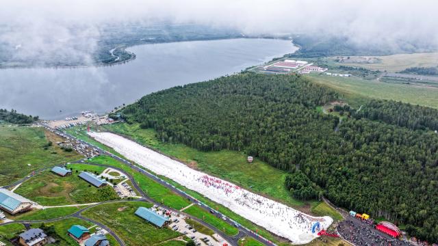 (260816) -- YAKESHI, Aug. 16, 2026 (Xinhua) -- An aerial drone photo taken on Aug. 16, 2026 shows tourists visiting the Phoenix Mountain scenic area in Yakeshi of Hulun Buir, north China's Inner Mongolia Autonomous Region. The scenic area has rolled out off-season ice-and-snow activities and cultural performances to draw visitors. (Xinhua/Lian Zhen)