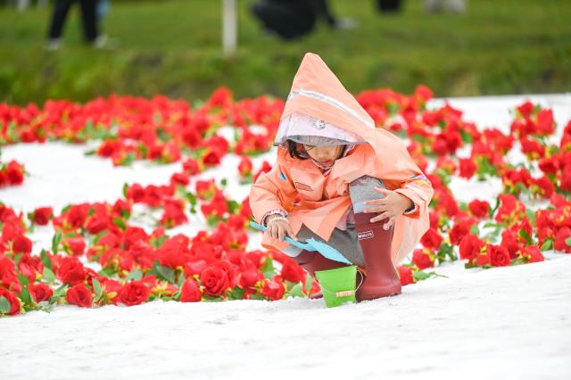 (260816) -- YAKESHI, Aug. 16, 2026 (Xinhua) -- A child has fun at the Phoenix Mountain scenic area in Yakeshi of Hulun Buir, north China's Inner Mongolia Autonomous Region, Aug. 16, 2026. The scenic area has rolled out off-season ice-and-snow activities and cultural performances to draw visitors. (Xinhua/Lian Zhen)