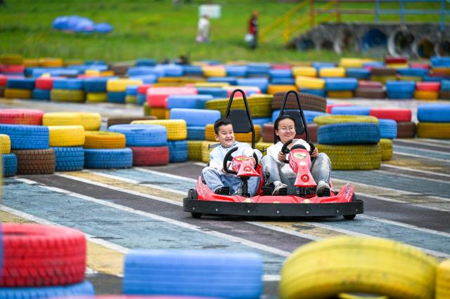 (260816) -- YAKESHI, Aug. 16, 2026 (Xinhua) -- Tourists have fun at the Phoenix Mountain scenic area in Yakeshi of Hulun Buir, north China's Inner Mongolia Autonomous Region, Aug. 16, 2026. The scenic area has rolled out off-season ice-and-snow activities and cultural performances to draw visitors. (Xinhua/Lian Zhen)