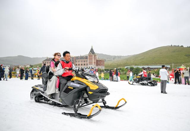(260816) -- YAKESHI, Aug. 16, 2026 (Xinhua) -- Tourists have fun at the Phoenix Mountain scenic area in Yakeshi of Hulun Buir, north China's Inner Mongolia Autonomous Region, Aug. 16, 2026. The scenic area has rolled out off-season ice-and-snow activities and cultural performances to draw visitors. (Xinhua/Lian Zhen)