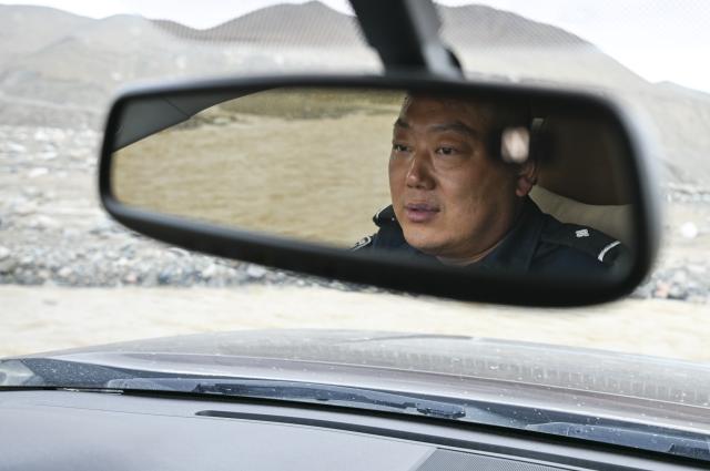 (260816) -- RUOQIANG, Aug. 16, 2026 (Xinhua) -- Ranger Li Jian drives across a river while patrolling the Altun Mountain National Nature Reserve in northwest China's Xinjiang Uygur Autonomous Region, on Aug. 8, 2026. Averaging 4,500 meters in elevation, the Altun Mountain National Nature Reserve, a 45,000-square-kilometer haven situated in the southeastern corner of Xinjiang, is subject to harsh environmental conditions. 
   In early August, a patrol team comprising nature reserve staff, local township officials and police officers ventured into this remote plateau wilderness for a monthly routine patrol.  
   Bumping along a dry river valley winding through the mountains, the team members checked for suspicious signs, observed wildlife, and maintained management station facilities. They conducted routine inspections within the reserve supported by advanced technological equipment, including high-altitude surveillance cameras, infrared cameras and drones. Their main mission was to curb illegal activities to ensure protection of one of China's most remote and ecologically vital sanctuaries. 
  At nearly 4,800 meters above sea level, almost every member of the team suffered from altitude sickness like headaches and insomnia, but their firm conviction to protect this reserve gave them strength to overcome challenges and carry on with their work. 
  Established in 1983, the reserve is managed by a team of about 70 people. Over the past 40 years, generation after generation of patrollers have devoted themselves to protecting this land with stark contrasts and rich biodiversity. (Xinhua/Hu Huhu)