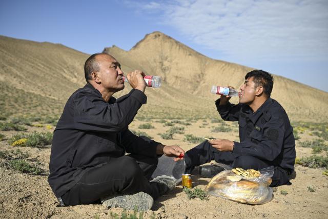 (260816) -- RUOQIANG, Aug. 16, 2026 (Xinhua) -- Rangers Arkin Juma (L) and Yusupjan Sulayman have meals while patrolling the Altun Mountain National Nature Reserve in northwest China's Xinjiang Uygur Autonomous Region, on Aug. 10, 2026. Averaging 4,500 meters in elevation, the Altun Mountain National Nature Reserve, a 45,000-square-kilometer haven situated in the southeastern corner of Xinjiang, is subject to harsh environmental conditions. 
   In early August, a patrol team comprising nature reserve staff, local township officials and police officers ventured into this remote plateau wilderness for a monthly routine patrol.  
   Bumping along a dry river valley winding through the mountains, the team members checked for suspicious signs, observed wildlife, and maintained management station facilities. They conducted routine inspections within the reserve supported by advanced technological equipment, including high-altitude surveillance cameras, infrared cameras and drones. Their main mission was to curb illegal activities to ensure protection of one of China's most remote and ecologically vital sanctuaries. 
  At nearly 4,800 meters above sea level, almost every member of the team suffered from altitude sickness like headaches and insomnia, but their firm conviction to protect this reserve gave them strength to overcome challenges and carry on with their work. 
  Established in 1983, the reserve is managed by a team of about 70 people. Over the past 40 years, generation after generation of patrollers have devoted themselves to protecting this land with stark contrasts and rich biodiversity. (Xinhua/Hu Huhu)