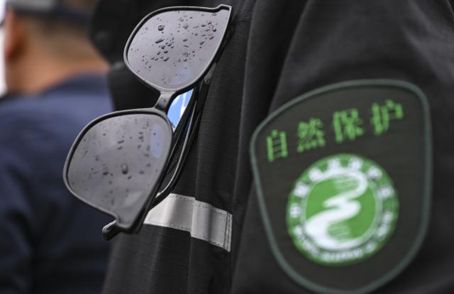 (260816) -- RUOQIANG, Aug. 16, 2026 (Xinhua) -- A pair of sunglasses of a patrol team member is pictured amid rain while rangers patrolling the Altun Mountain National Nature Reserve in northwest China's Xinjiang Uygur Autonomous Region, on Aug. 8, 2026. Averaging 4,500 meters in elevation, the Altun Mountain National Nature Reserve, a 45,000-square-kilometer haven situated in the southeastern corner of Xinjiang, is subject to harsh environmental conditions. 
   In early August, a patrol team comprising nature reserve staff, local township officials and police officers ventured into this remote plateau wilderness for a monthly routine patrol.  
   Bumping along a dry river valley winding through the mountains, the team members checked for suspicious signs, observed wildlife, and maintained management station facilities. They conducted routine inspections within the reserve supported by advanced technological equipment, including high-altitude surveillance cameras, infrared cameras and drones. Their main mission was to curb illegal activities to ensure protection of one of China's most remote and ecologically vital sanctuaries. 
  At nearly 4,800 meters above sea level, almost every member of the team suffered from altitude sickness like headaches and insomnia, but their firm conviction to protect this reserve gave them strength to overcome challenges and carry on with their work. 
  Established in 1983, the reserve is managed by a team of about 70 people. Over the past 40 years, generation after generation of patrollers have devoted themselves to protecting this land with stark contrasts and rich biodiversity. (Xinhua/Hu Huhu)