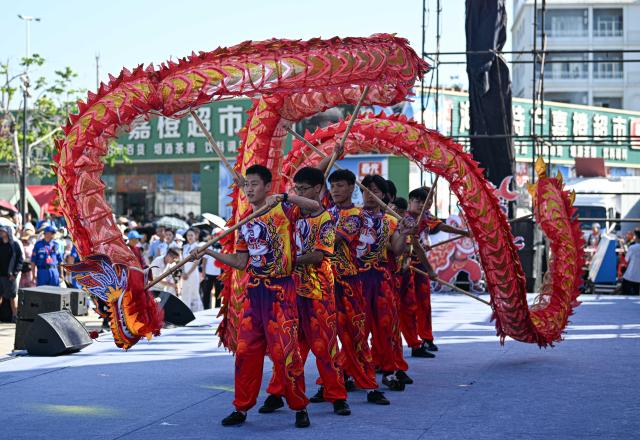 (260816) -- QIONGHAI, Aug. 16, 2026 (Xinhua) -- Performers stage a dragon dance in celebration of a new fishing season near Tanmen port in Qionghai, south China's Hainan Province, on Aug. 16, 2026. The fishing season of the South China Sea kicked off at noon on Sunday after this summer's three-and-a-half-month fishing ban. (Xinhua/Pu Xiaoxu)