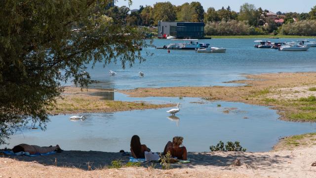 (260816) -- BELGRADE, Aug. 16, 2026 (Xinhua) -- People rest on the bank of the Danube River in Belgrade, Serbia, on Aug. 16, 2026. Riverbed was exposed as the water level of the Danube River approached record-low by severe drought. (Photo by Wang Wei/Xinhua)