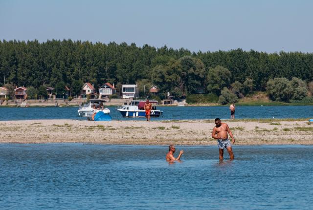 (260816) -- BELGRADE, Aug. 16, 2026 (Xinhua) -- People cool off in the Danube River in Belgrade, Serbia, on Aug. 16, 2026. Riverbed was exposed as the water level of the Danube River approached record-low by severe drought. (Photo by Wang Wei/Xinhua)
