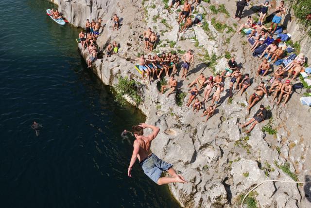 (260817) -- KANAL OB SOCI, Aug. 17, 2026 (Xinhua) -- A participant jumps into the River Soca from a 17-meter-high bridge during a traditional jumping event in Kanal ob Soci, Slovenia, on Aug. 16, 2026. (Photo by Zeljko Stevanic/Xinhua)