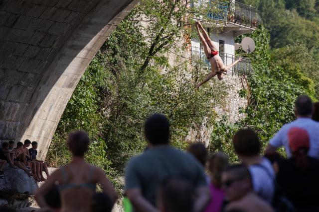 (260817) -- KANAL OB SOCI, Aug. 17, 2026 (Xinhua) -- A participant jumps into the River Soca from a 17-meter-high bridge during a traditional jumping event in Kanal ob Soci, Slovenia, on Aug. 16, 2026. (Photo by Zeljko Stevanic/Xinhua)