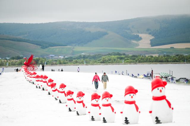 (260817) -- BEIJING , Aug. 17, 2026 (Xinhua) -- Tourists visit the Phoenix Mountain scenic area in Yakeshi of Hulun Buir, north China's Inner Mongolia Autonomous Region, Aug. 16, 2026. The scenic area has rolled out off-season ice-and-snow activities and cultural performances to draw visitors. (Xinhua/Lian Zhen)