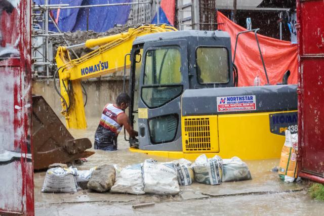 (260817) -- QUEZON CITY, Aug. 17, 2026 (Xinhua) -- A man checks an excavator submerged in floodwater in Quezon City, the Philippines, on Aug. 17, 2026. The Philippine government has suspended in-person classes in Metro Manila and 12 other provinces as heavy rains from tropical cyclones and the southwest monsoon continue to batter the country, local media reported on Monday.
   The extreme rainfall has triggered severe flooding and landslides across the nation. The well-known flood-control corruption scandal has left key infrastructure unfinished or poorly maintained, further straining the country's disaster response, local media reported. (Xinhua/Rouelle Umali)