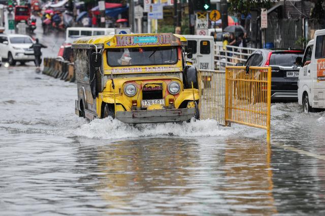 (260817) -- QUEZON CITY, Aug. 17, 2026 (Xinhua) -- A jeepney drives through floodwater in Quezon City, the Philippines, on Aug. 17, 2026. The Philippine government has suspended in-person classes in Metro Manila and 12 other provinces as heavy rains from tropical cyclones and the southwest monsoon continue to batter the country, local media reported on Monday.
   The extreme rainfall has triggered severe flooding and landslides across the nation. The well-known flood-control corruption scandal has left key infrastructure unfinished or poorly maintained, further straining the country's disaster response, local media reported. (Xinhua/Rouelle Umali)