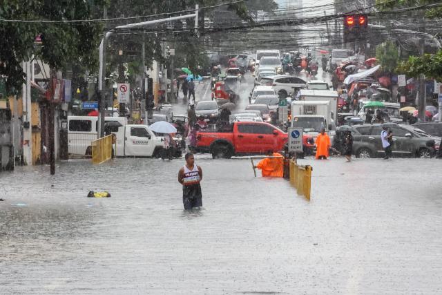 (260817) -- QUEZON CITY, Aug. 17, 2026 (Xinhua) -- A man wades through floodwater in Quezon City, the Philippines, on Aug. 17, 2026. The Philippine government has suspended in-person classes in Metro Manila and 12 other provinces as heavy rains from tropical cyclones and the southwest monsoon continue to batter the country, local media reported on Monday.
   The extreme rainfall has triggered severe flooding and landslides across the nation. The well-known flood-control corruption scandal has left key infrastructure unfinished or poorly maintained, further straining the country's disaster response, local media reported. (Xinhua/Rouelle Umali)