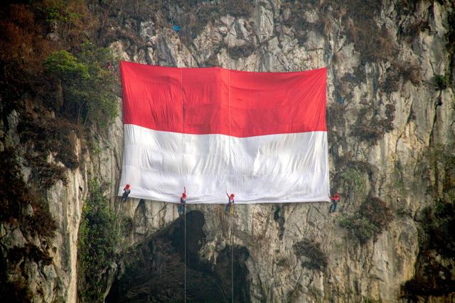 (260817) -- JAKARTA, Aug. 17, 2026 (Xinhua) -- People hang a national flag during a celebration event of the 81st anniversary of the founding of the Republic of Indonesia at Mount Hawu in West Java, Indonesia, Aug. 17, 2026. (Photo by Septianjar Muharam/Xinhua)