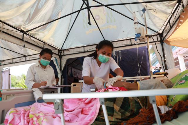 (260817) -- JAKARTA, Aug. 17, 2026 (Xinhua) -- Health workers treat a patient at an emergency tent outside Komodo Regional Hospital, East Nusa Tenggara Province, Indonesia, Aug. 17, 2026. The death toll from a 7.7-magnitude earthquake that struck Indonesia's East Nusa Tenggara (NTT) province has risen to 68, the National Disaster Management Agency (BNPB) said Monday. (Indonesia's Ministry of Health/Handout via Xinhua)