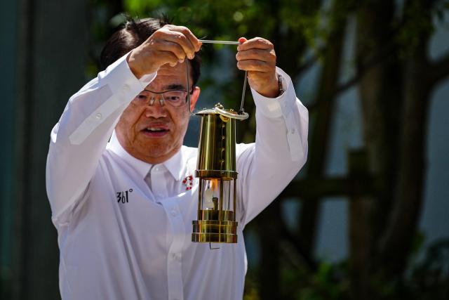 (260818) -- TOKYO, Aug. 18, 2026 (Xinhua) -- Aichi Governor and organizing committee president Hideaki Omura displays the flame lantern during the flame lighting ceremony for the 20th Asian Games in Tokyo, Japan, on Aug. 18, 2026. (Xinhua/Jia Haocheng)