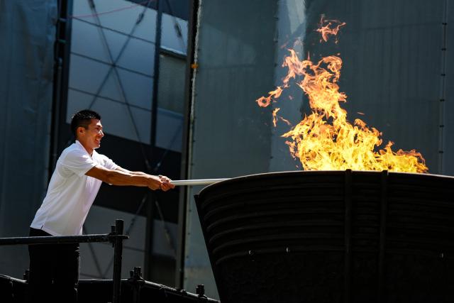 (260818) -- TOKYO, Aug. 18, 2026 (Xinhua) -- Japanese sprinter Kiryu Yoshihide lights the torch from the cauldron during the flame lighting ceremony for the 20th Asian Games in Tokyo, Japan, on Aug. 18, 2026. (Xinhua/Jia Haocheng)