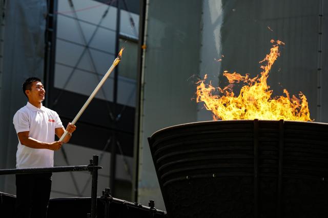 (260818) -- TOKYO, Aug. 18, 2026 (Xinhua) -- Japanese sprinter Kiryu Yoshihide displays the lit torch during the flame lighting ceremony for the 20th Asian Games in Tokyo, Japan, on Aug. 18, 2026. (Xinhua/Jia Haocheng)