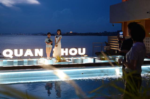 (260818) -- HUI'AN, Aug. 18, 2026 (Xinhua) -- People pose for photos at the Chongwu ancient ferry terminal scenic area in Hui'an County of Quanzhou, southeast China's Fujian Province, Aug. 17, 2026. The Chongwu ancient ferry terminal covers an area of 33 mu (about 2.2 hectares) in Hui'an County of southeast China's Fujian Province. In 2024, local authorities transformed it from an idle terminal into a coastal vacation destination that integrates art galleries, a pier runway, trendy restaurants, and family playgrounds. (Xinhua/Lin Shanchuan)