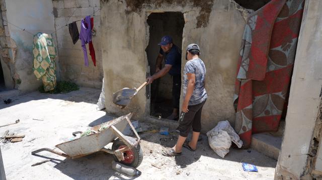 (260818) -- QALAAT AL-MADIQ, Aug. 18, 2026 (Xinhua) -- Mohammed (L) clears debris from his damaged home with the help of his son inside Qalaat al-Madiq in Hama province, central Syria, June 24, 2026.
  TO GO WITH "Letter from Mideast: In a Syrian castle, a laurel still stands" (Photo by Monsef Memari/Xinhua)