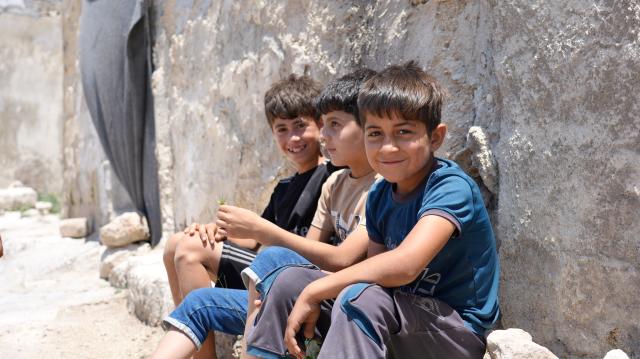 (260818) -- QALAAT AL-MADIQ, Aug. 18, 2026 (Xinhua) -- Children sit along an ancient stone wall inside Qalaat al-Madiq in Hama province, central Syria, June 24, 2026.
  TO GO WITH "Letter from Mideast: In a Syrian castle, a laurel still stands" (Photo by Monsef Memari/Xinhua)