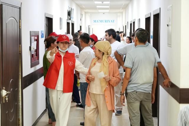 (260818) -- TASHKENT, Aug. 18, 2026 (Xinhua) -- A Chinese volunteer guides a local patient at an ophthalmic medical institution in Tashkent, Uzbekistan, Aug. 17, 2026. A Chinese volunteer medical team launched a charitable eye care program in the Uzbek cities of Tashkent and Kokand on Monday, offering free cataract surgeries to locals. (Xinhua/Zafar Khalilov)