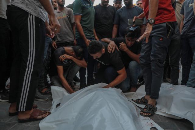 (260818) -- GAZA, Aug. 18, 2026 (Xinhua) -- Palestinians mourn over victims who were killed by an Israeli airstrike that hit a cafe, at al-Shifa Hospital, in Gaza City, on Aug. 18, 2026. At least six Palestinians, including a child, were killed and 14 others injured on Tuesday in an Israeli airstrike that hit a cafe in the seaport area west of Gaza City. (Photo by Rizek Abdeljawad/Xinhua)