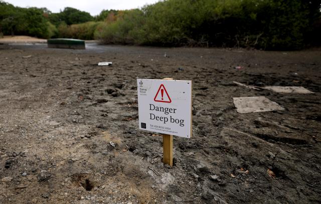 (260818) -- LONDON, Aug. 18, 2026 (Xinhua) -- A warning sign is placed in dried and cracked bed of the Hollow Pond in London, Britain, on Aug. 18, 2026. In Britain, extreme dryness becomes a defining feature of the summer. Provisional data from the Met Office showed that England and Wales experienced their driest July on record, while nearly three-quarters of England was officially under drought conditions by Aug. 10. (Xinhua/Li Ying)