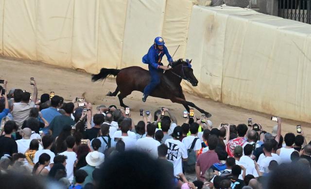 (260819) -- SIENA, Aug. 19, 2026 (Xinhua) -- Palio jockey Giovanni Atzeni, also known as "Tittia," competes during the Palio in Siena, Italy, Aug. 18, 2026. Palio in Siena, or "Palio di Siena" in Italian, is a historical horse race held twice a year in Siena since 1656. (Photo by Alberto Lingria/Xinhua)