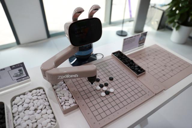 (260819) -- BEIJING, Aug. 19, 2026 (Xinhua) -- An AI-powered chess robot of SenseRobot plays a board game with a visitor in Beijing E-Town of Beijing, capital of China, July 1, 2026. The Beijing Economic-Technological Development Area, also known as Beijing E-Town, has managed to cultivate and strengthen a modern system of emerging and forward-looking industries. (Photo by Ma Zihan/Xinhua)