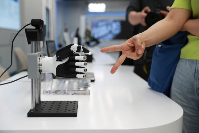 (260819) -- BEIJING, Aug. 19, 2026 (Xinhua) -- A dexterous hand plays "rock-paper-scissors" with a visitor at the Beijing Innovation Center of Humanoid Robotics in Beijing, capital of China, July 1, 2026. The Beijing Economic-Technological Development Area, also known as Beijing E-Town, has managed to cultivate and strengthen a modern system of emerging and forward-looking industries. (Photo by Ma Zihan/Xinhua)