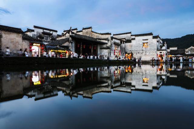 (260819) -- HUANGSHAN, Aug. 19, 2026 (Xinhua) -- Tourists visit a pond at dusk in Hongcun Village, Yixian County of Huangshan City, east China's Anhui Province, Aug. 18, 2026. (Xinhua/Chang Nengjia)