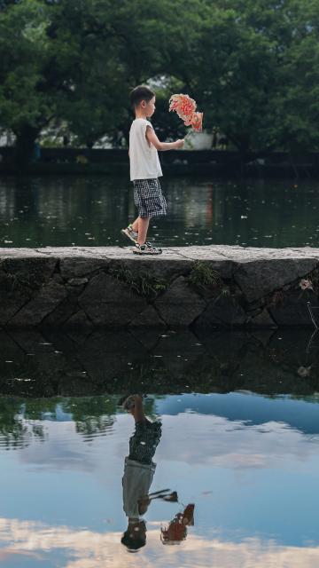 (260819) -- HUANGSHAN, Aug. 19, 2026 (Xinhua) -- A child holding a fish lantern enjoys himself in Hongcun Village, Yixian County of Huangshan City, east China's Anhui Province, Aug. 18, 2026. (Xinhua/Chang Nengjia)