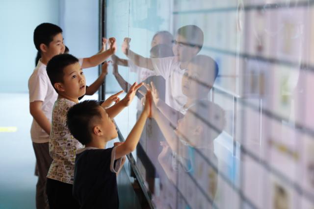 (260819) -- FUZHOU, Aug. 19, 2026 (Xinhua) -- Children visit the Museum of Foochow Arsenal 1866 in Mawei District of Fuzhou, southeast China's Fujian Province, Aug. 18, 2026. Fuzhou city has managed to revitalize its industrial heritage themed on "Chuanzheng" (ship building and administration) to boost tourism development. The Museum of Foochow Arsenal 1866 displays the history and culture of Chuanzheng, while the themed immersive performance entitled "The Glory Belongs to Foochow Arsenal" brings the audience through a time tunnel to vividly revisit the growth of Chuanzheng in this city. (Xinhua/Du Xiaoyi)