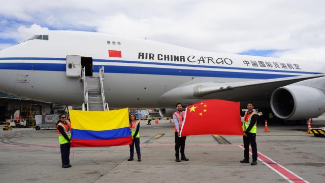 (260819) -- BOGOTA, Aug. 19, 2026 (Xinhua) -- Staff members pose for photos with the national flags of China and Colombia upon the arrival of humanitarian earthquake relief supplies provided by the Chinese government at an airport in Bogota, Colombia, Aug. 18, 2026. Humanitarian earthquake relief supplies provided by the Chinese government arrived in Bogota on Tuesday to support Colombia's disaster response and post-disaster reconstruction efforts. (Xinhua/Li Zijian)