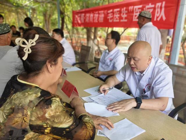 (260819) -- URUMQI, Aug. 19, 2026 (Xinhua) -- Li Yong (R), a medic from central China's Hunan Province, offers voluntary medical consultation in Turpan, northwest China's Xinjiang Uygur Autonomous Region, July 12, 2025. TO GO WITH "Feature: Meet 'Dr. Mao,' the medics help improve healthcare in northwestern frontier" (Xinhua)