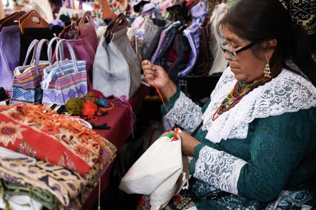 (260819) -- MEXICO CITY, Aug. 19, 2026 (Xinhua) -- An artisan embroiders on a cloth bag during the 12th Indigenous Cultures Festival at Constitution Square in Mexico City, capital of Mexico, Aug. 18, 2026. Inside a large exhibition tent, visitors browse goods and taste local specialty drinks, while artisans demonstrate traditional skills such as embroidery. The festival will run until Aug. 23. (Xinhua/Liu Wenhui)